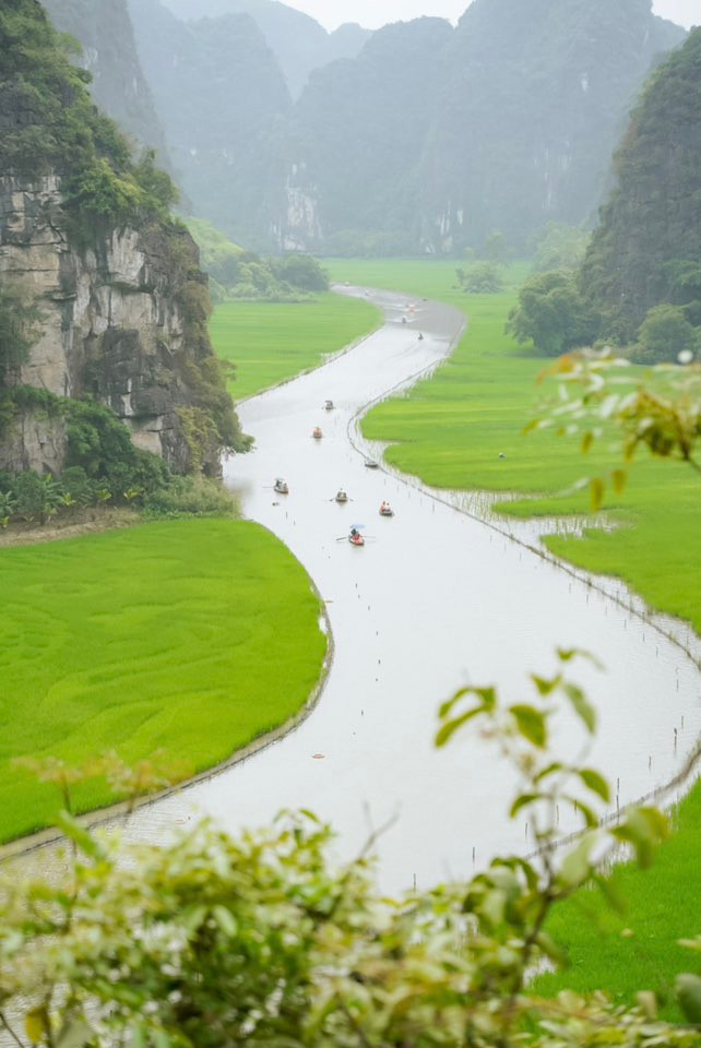 Dòng sông trong veo uốn mình quanh co giữa hai triền núi đá sừng sững, ôm lấy những cánh đồng lúa xanh trải dài tít tắp. Ảnh Chuyến đi của Tali