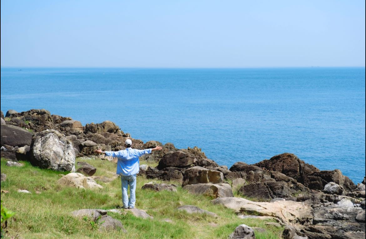 Dưới ánh nắng, các khối đá ánh lên màu nâu sẫm, nổi bật giữa làn nước biển trong vắt và những mảng rừng xanh rì. Không gian nơi đây mang đến cảm giác vừa hoang dã, vừa thơ mộng – một khung cảnh hiếm thấy giữa một thành phố du lịch nổi tiếng.