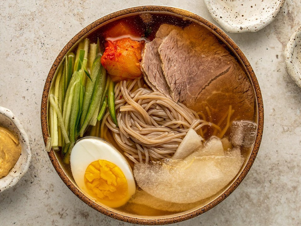 Món ăn này bao gồm sợi mì dai, thường được làm từ bột kiều mạch, kèm theo nước dùng lạnh được chế biến từ thịt bò hoặc gà, tạo ra một sự kết hợp hoàn hảo giữa hương vị đậm đà và thanh mát. Ảnh Internet