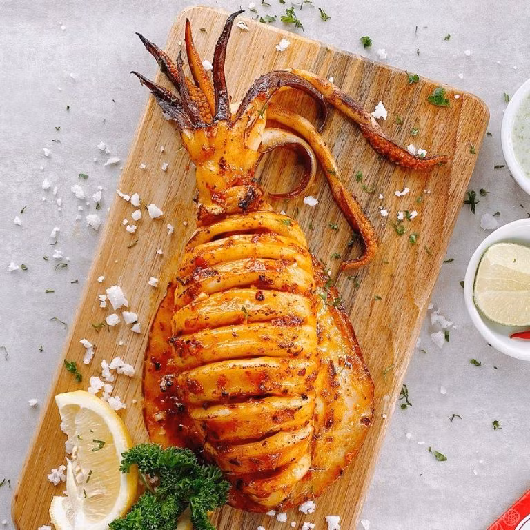 Mực ở Lý Sơn được đánh bắt ngay trong ngày và chế biến liền tại chỗ nên cực kỳ tươi ngon. Mực nhảy khi vừa bắt lên còn căng tròn, được nướng trên than hồng, giữ trọn hương vị ngọt thanh, dai giòn tự nhiên. Ảnh Internet