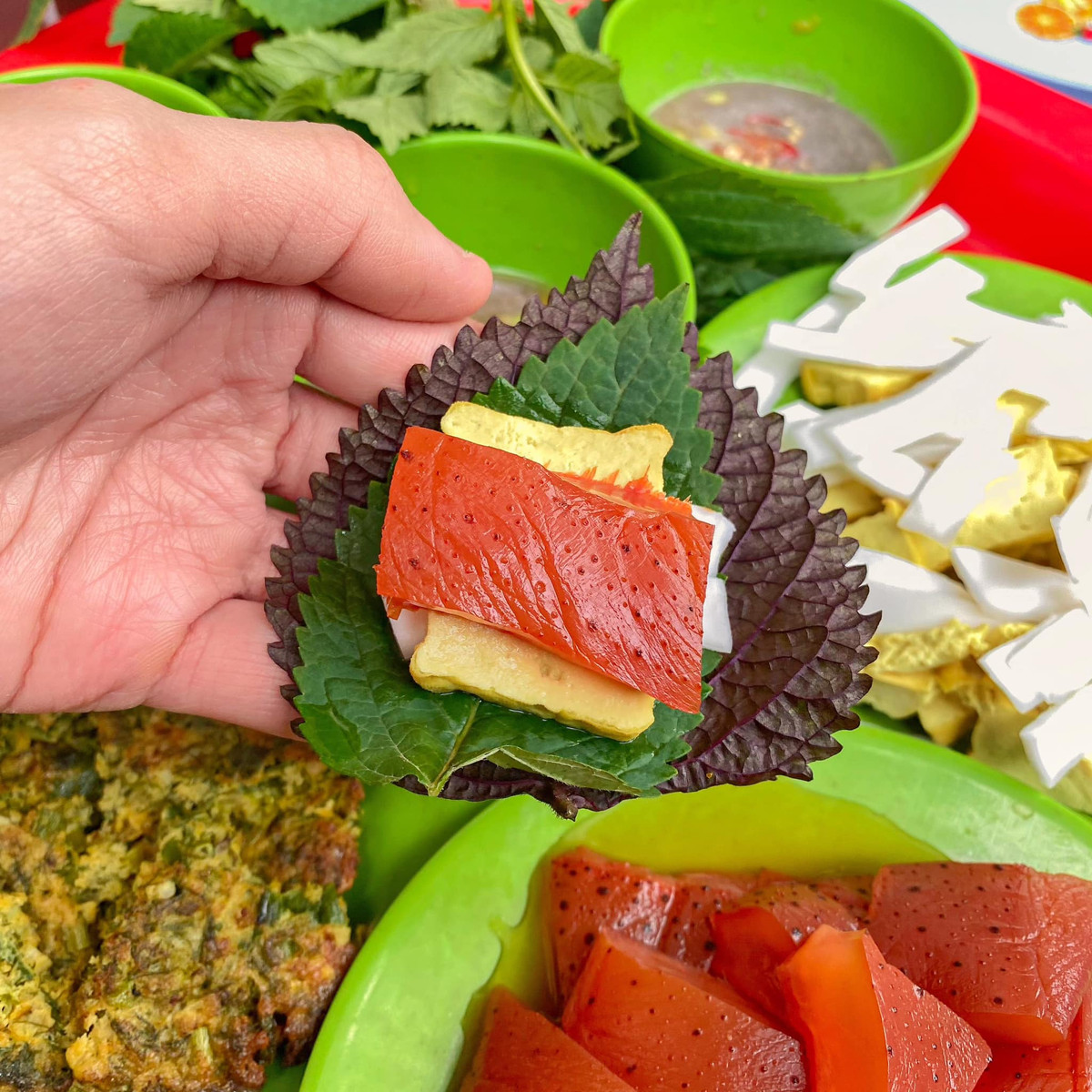 Món sứa đỏ khi ăn thường được bày cùng các nguyên liệu dân dã như đậu phụ mơ chấm nước mắm nhạt, dừa tươi thái sợi, rau kinh giới, tía tô và đặc biệt là mắm tôm đánh bông. Ảnh Internet