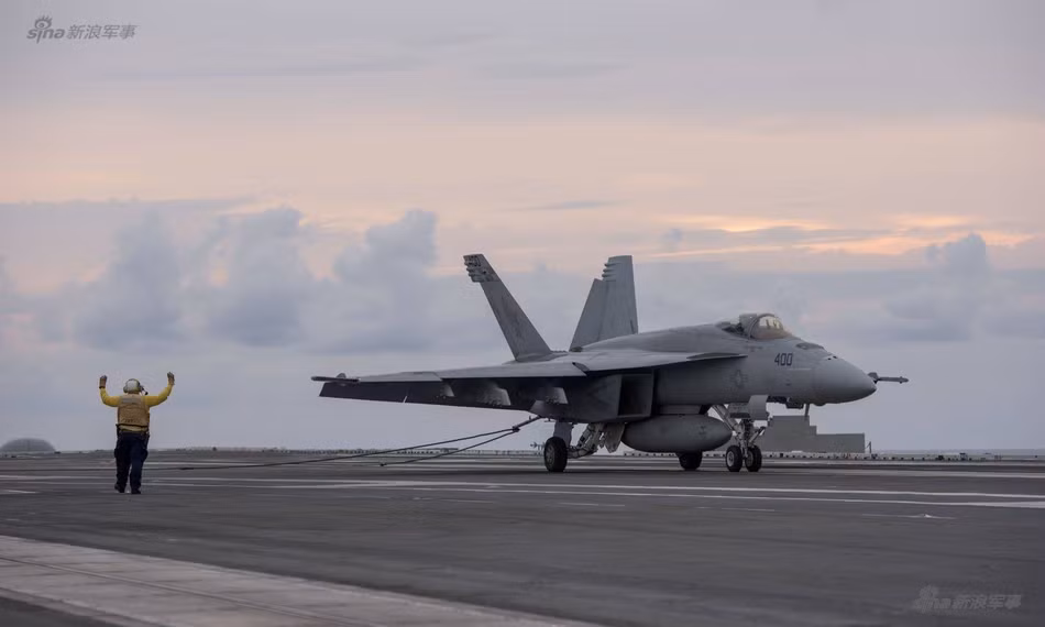 Ngoài việc tuần tra các vùng biển quanh khu vực đông Á, tàu sân bay USS Ronald Reagan cũng luôn thực hiện các bài tập bay liên tục cả ngày lẫn đêm để các phi công chiến đấu cũng như lực lượng hỗ trợ trên tàu có cơ hội được tập luyện, cọ sát một cách thật nhất có thể. Ảnh: Chiến đấu cơ F-18 của Không quân Hải quân Mỹ hạ cánh trên tàu sân bay với hệ thống dây móc hãm đà. Nguồn ảnh: Sina.