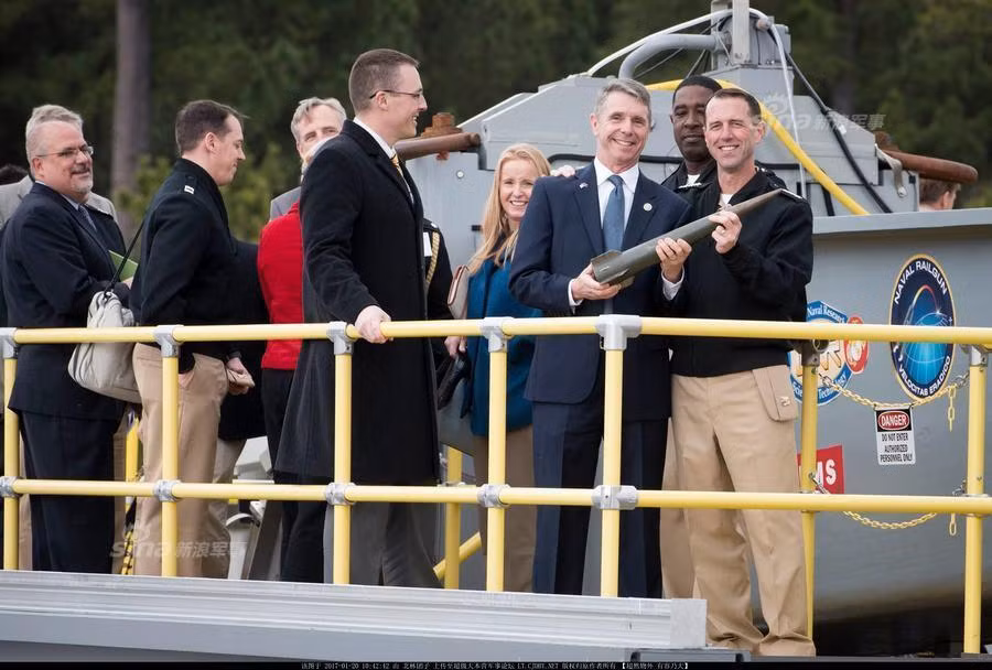 Giới chức quân sự Mỹ cùng các nhà khoa học cầm trên tay viên đạn của khẩu súng điện từ được Mỹ bắn thử thành công vào dịp đầu năm 2017 vừa rồi. Nguồn ảnh: Sina.