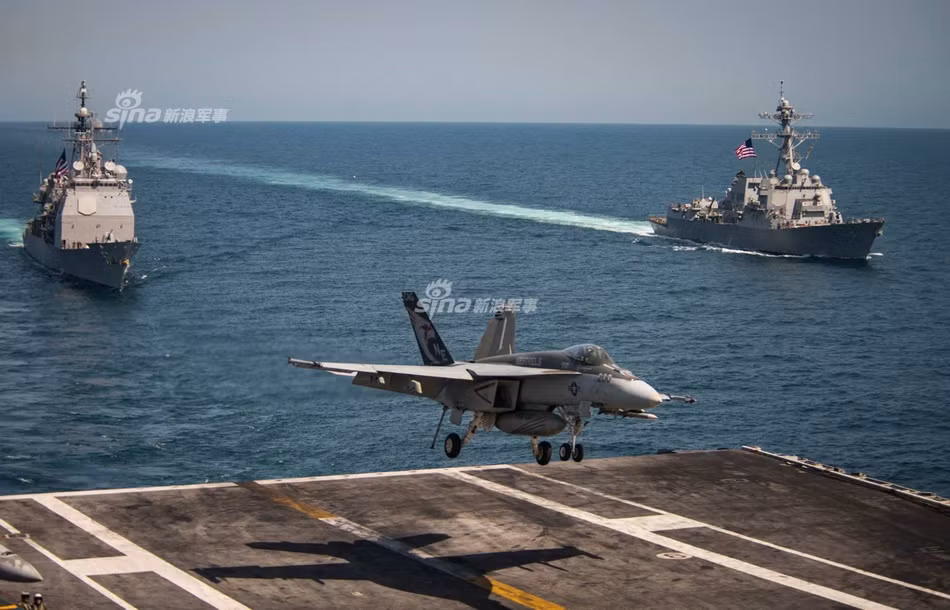 Máy bay F/A-18 của Không quân Hải quân Mỹ đang hạ cánh trên chiếc tàu sân bay USS Carl Vinson, phía sau là hai khu trục hạm của Hải quân Mỹ, bên trái là USS Mitscher (DDG-57) và bên phải là USS Wayne E. Meyer (DDG-108). Nguồn ảnh: Sina.