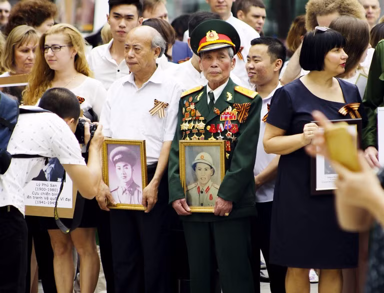 Có những người mang theo cả ảnh của người thân, của đồng đội đã hy sinh đến cuộc diễu hành này.