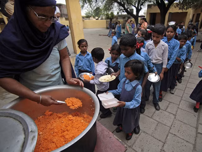 Jammu, Ấn Độ: Trẻ em đang xếp hàng để nhận những bữa ăn trưa miễn phí với xôi tại một trường học công lập của nhà nước.