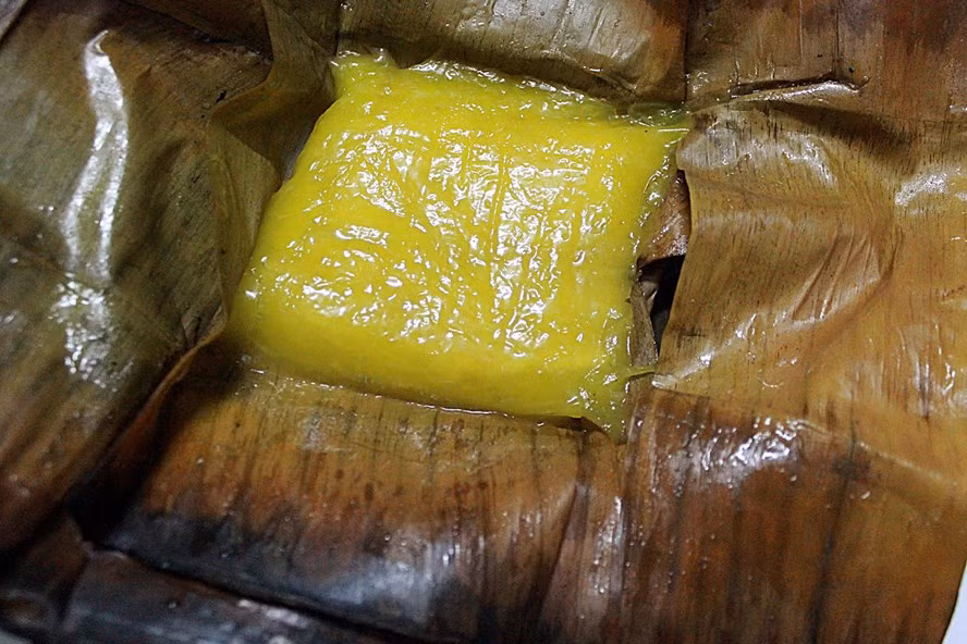 Bánh phu thê Đình Bảng: Được gói bằng những tấm lá dong giản dị, rồi luộc lên, bánh phu thê không khoe mùi tỏa hương như bánh rán, bánh khúc; chỉ tới khi bóc bánh đặt lên đĩa sứ người ta mới thật sự ngỡ ngàng. Dưới lớp vỏ bánh sắc vàng trong suốt rắc lấm tấm những hạt vừng đen, nhân bánh hiện ra. Ngoài đỗ xanh đãi sạch vỏ đã được hấp chín đánh tơi, người ta còn cho thêm đường trắng, cùi dừa, hạt sen và các hương ngũ vị. Ảnh: Laodong.