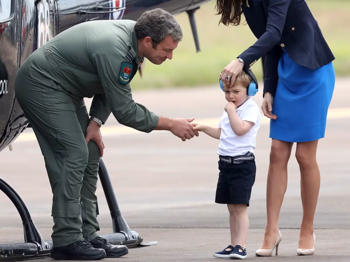 Hoàng tử George ngại ngùng khi bắt tay một phi công tại triển lãm Royal International Air Tattoo vào năm 2016.