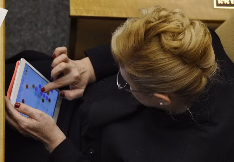 Khi quá nhàm chán với những phiên họp, họ chuyển sang "nghiên cứu" trò chơi trên iPad. Ảnh: ER.