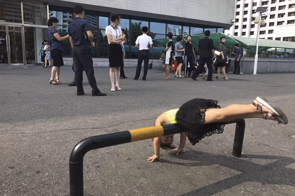 Cô gái trẻ chơi trên đường sắt an toàn tại bãi đậu xe ở phía trước một cửa hàng bách hóa địa phương vào ngày 23/7 tại Bình Nhưỡng. Ảnh: AP.