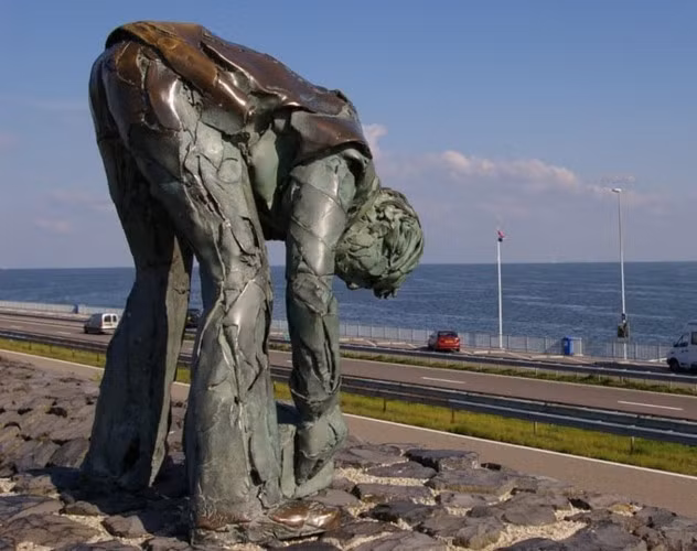 Cách đó không xa là tượng đài của những người đã trực tiếp đặt từng viên đá xây nên công trình đáng ngưỡng mộ này. Đó là tượng đài bằng đồng và bê tông, mô tả một người công nhân, với những vết rạn vỡ trên thân hình, đang cúi gập người nâng một viên đá.