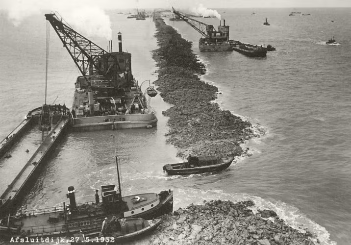 Tiếp theo, các phương tiện thi công cơ giới bao mặt đê, gia cố móng bằng đá bazan. Tại một số điểm đặc biệt yếu, có độ sâu lớn, tương ứng với tác động của dòng triều mạnh, các chuyên gia Hà Lan đã phải tiến hành một số biện pháp đặc biệt và thi công gia cố bổ sung.