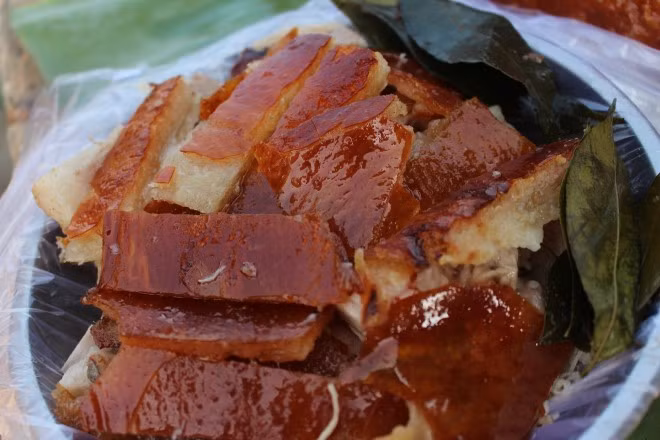 Lợn quay Lạng Sơn: Ai đã từng đến Lạng Sơn chắc hẳn khó quên hương vị đậm đà của món lợn quay nhồi quả và lá mắc mật. Đây vốn là món ăn đặc sản sang trọng không thể thiếu trong cỗ bàn của người xứ Lạng. Món Lợn quay ngon vì được nghệ nhân dân gian chế biến môt cách cầu kỳ, có hương vị rất riêng, có vị ngọt béo ngậy của thịt vừa chín tới, vị thơm của quả và lá mắc mật, ăn một lần nhớ mãi. Ảnh: Thethaovanhoa.