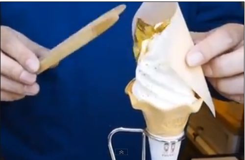 Cận cảnh công đoạn dát vàng lên que kem ốc quế của người bán kem.