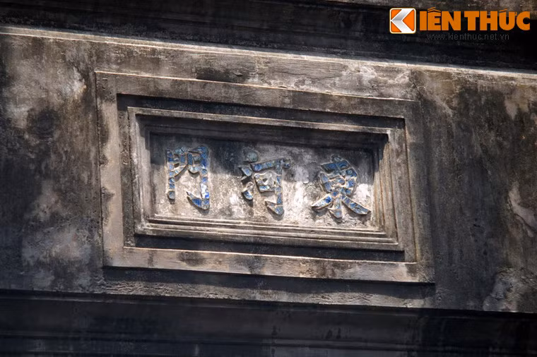 Ở mặt trước, giữa phần trên nóc cửa chính và vọng lâu có một khung hình chữ nhật đắp nổi ba chữ Hán bằng mảnh sứ màu xanh: "Đông Hà Môn".