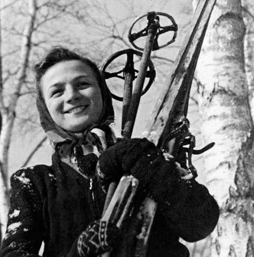 Nữ vận động viên trượt tuyết cười tươi tạo dáng.