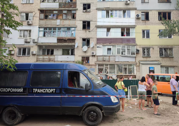 Người dân địa phương đứng gần tòa chung cư bị hư hại trong cuộc tấn công bằng tên lửa của Nga tại Mykolaiv ngày 19/07/2024.