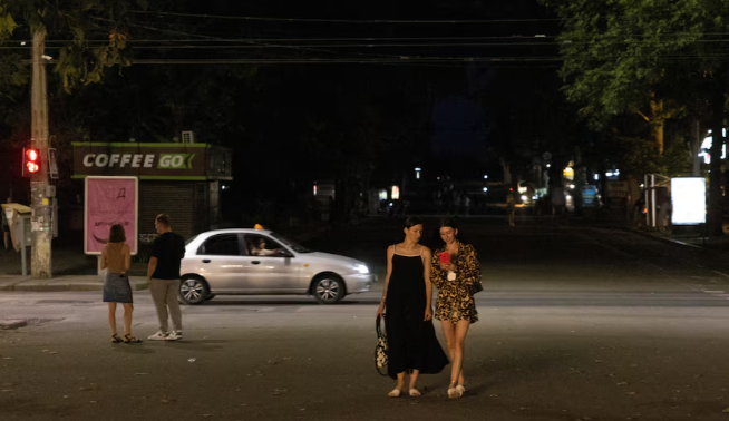 Người dân đi bộ trên phố đi bộ trung tâm của thành phố trong thời gian mất điện ở Mykolaiv, Ukraine, ngày 04/07/2024.