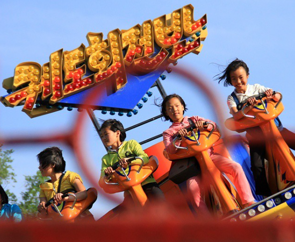 Các em nhỏ thích thú chơi trò chơi tại Hội chợ Kaeson ở Bình Nhưỡng năm 2015.