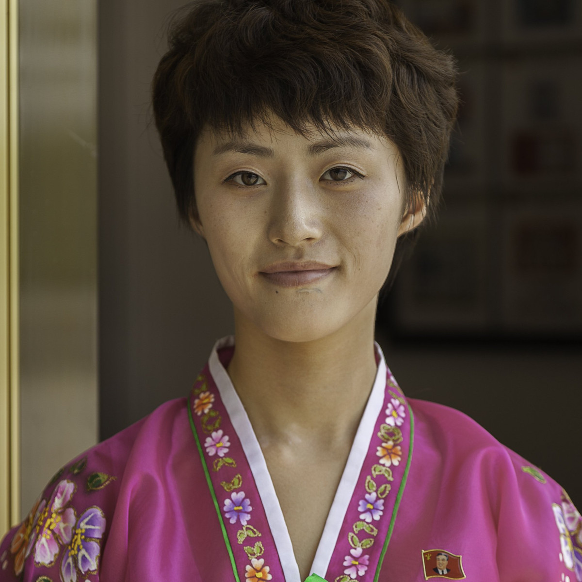 Trong ảnh là một nhân viên bán hàng mặc trang phục truyền thống đứng trước một cửa hàng lưu niệm ở Kaesong, tỉnh Bắc Hwanghae.