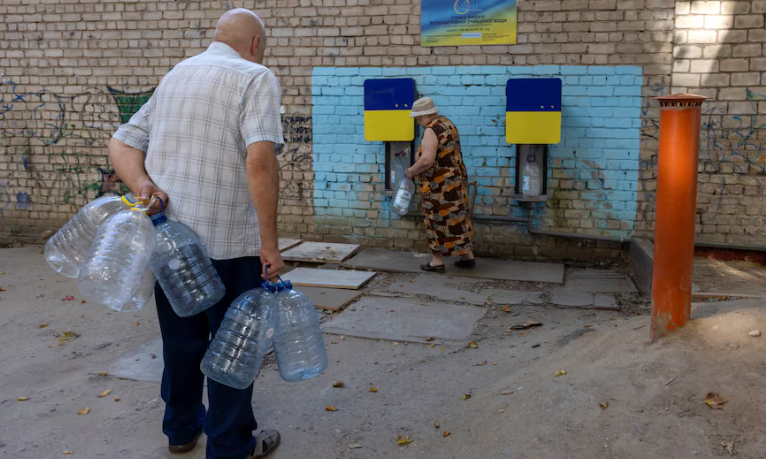 Theo Reuters, người dân ở Mykolaiv đối mặt với tình trạng thiếu nước máy sạch sau khi cuộc tấn công của lực lượng Nga đã phá hủy các đường ống và một trạm bơm tại thành phố này. Ảnh: Một phụ nữ lấy nước lọc từ trạm phân phối ở Mykolaiv ngày 05/07. (Nguồn ảnh: Reuters)