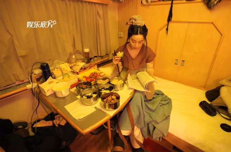 Giờ ăn trưa, Phạm Băng Băng cũng lặng lẽ ăn một mình và vừa ăn và chăm chú đọc kịch bản cho cảnh quay tiếp trên phim trường Võ Mị Nương truyền kỳ.