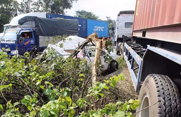 Vụ tai nạn khiến chiếc xe du lịch bẹp dúm, biến dạng hoàn toàn. Hai cha con anh Dũng dính chặt trong xe kêu cứu thảm thiết.