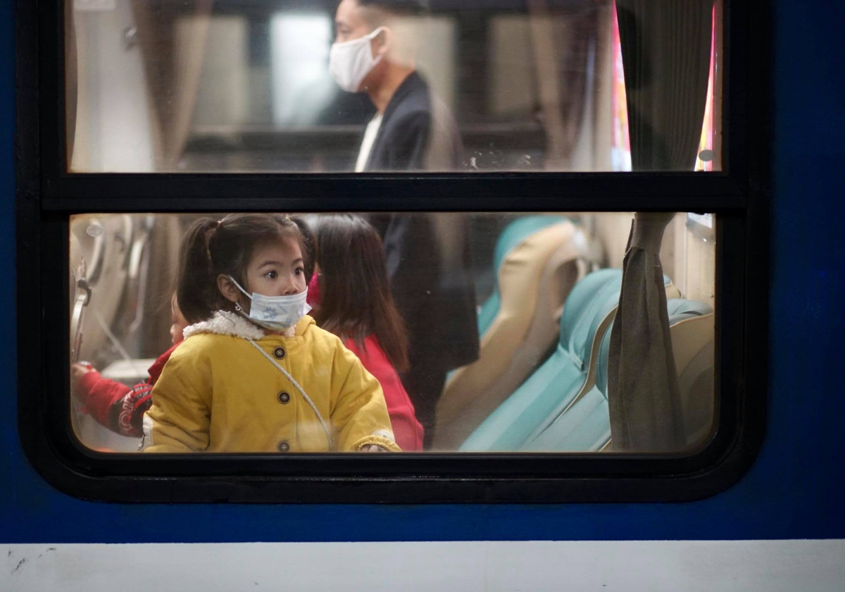 Một hành khách nhí, háo hức chuẩn bị được đoàn tụ với gia đình.