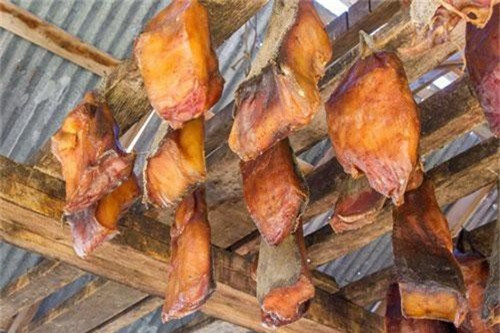 “Cá mập thối” hay Hákarl là món ăn truyền thống của người dân Iceland trong đêm giáng sinh. Đây là một trong những món ăn thử thách của rất nhiều khách du lịch khi đến thăm Iceland. Vì thịt cá mập được đem chôn xuống lòng đất từ 6-12 tuần rồi mới đưa lên thưởng thức nên mùi vị của món ăn này thật sự rất khủng khiếp. Do đó, để át đi độ nặng mùi của thịt cá mập, bạn sẽ được gợi ý uống kèm món rượu Brennivin. Ảnh: Pac Group.