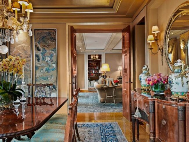 Phòng khách có lò sưởi bằng đá cẩm thạch cổ và cửa kiểu Pháp mở ra sân hiên.