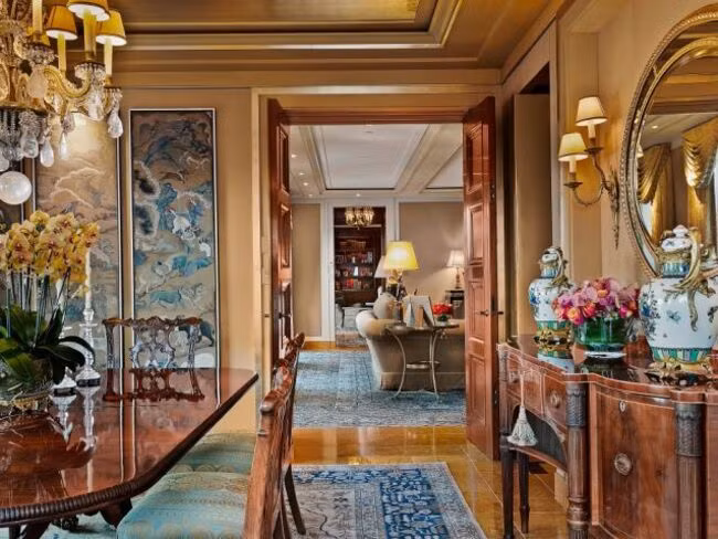 Phòng khách có lò sưởi bằng đá cẩm thạch cổ và cửa kiểu Pháp mở ra sân hiên.