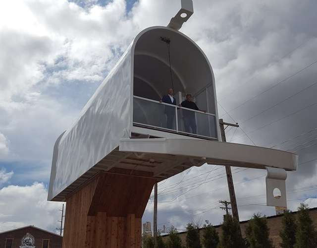 Công trình này được làm từ những vật liệu tái chế. Du khách có thể di chuyển bằng cầu thang lên trên hộp thư để ngắm nhìn khung cảnh độc đáo của thị trấn.