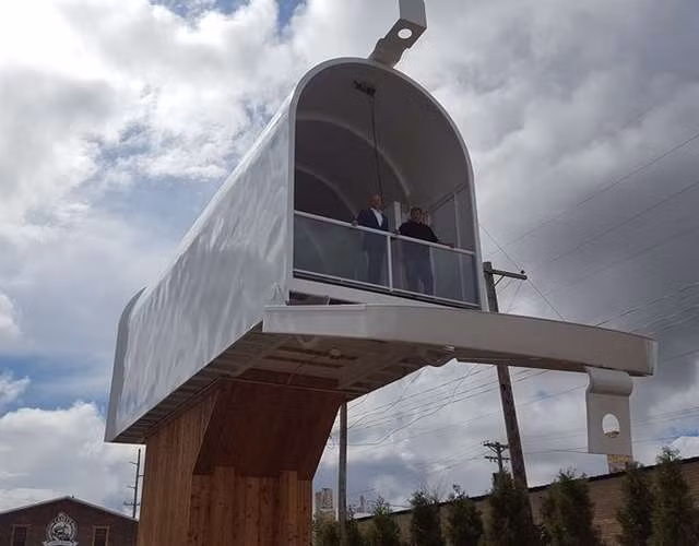 Công trình này được làm từ những vật liệu tái chế. Du khách có thể di chuyển bằng cầu thang lên trên hộp thư để ngắm nhìn khung cảnh độc đáo của thị trấn.