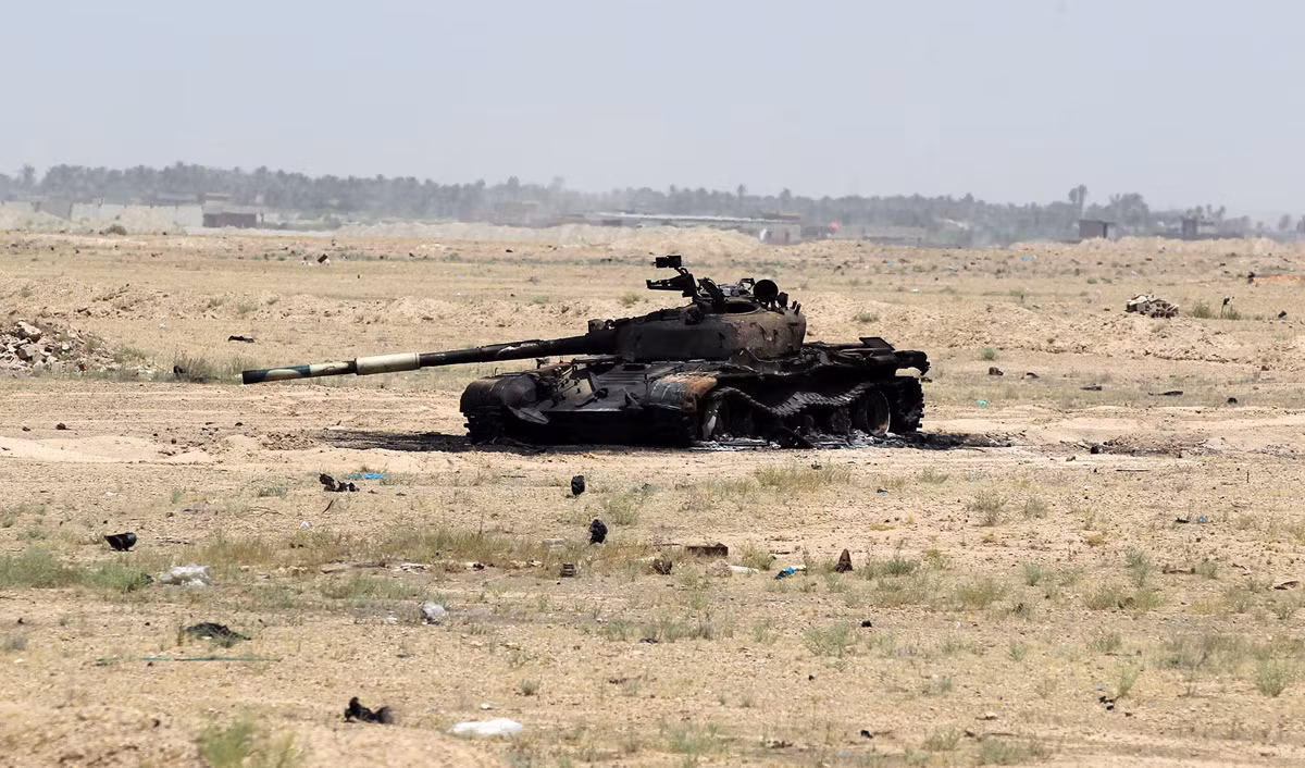 Một xe tăng cháy rụi trên một mảnh đất cằn cỗi.