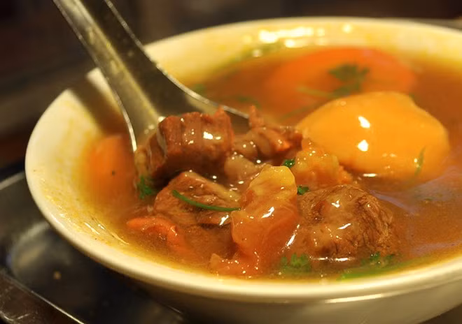  Bánh mì sốt vang. Nằm tại phố Đình Ngang, đoạn giao ngã ba Cửa Nam là quán bánh mì sốt vang đã nổi tiếng hàng chục năm nay. Quán mở từ 3h chiều tới 11h30 đêm, sẵn sàng phục vụ mọi thực khách. Bánh mì sốt vang ở đây được nấu khá đặc biệt. Phần thịt bò thường là dẻ sườn, gân được tẩm ướp nhiều loại gia vị khác nhau, sau đó đem hầm. Màu đỏ đẹp mắt của món này cũng từ màu của quả gấc. 