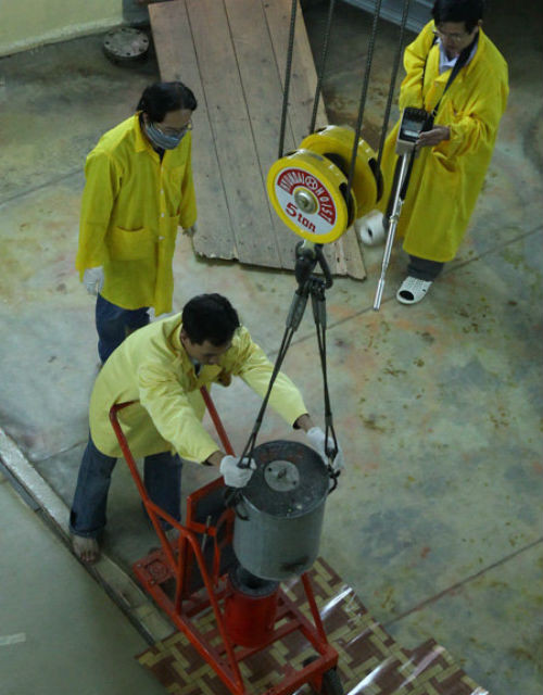 Chuyển đồng vị phóng xạ từ thùng chì sang container vào khu vực điều chế dược phẩm