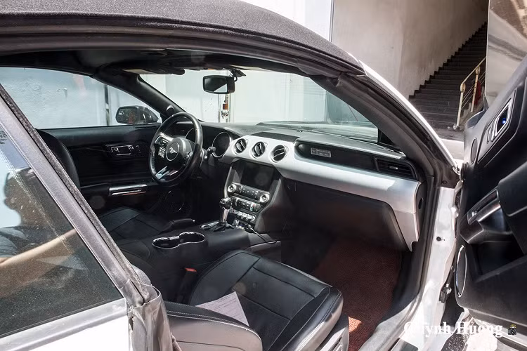 Ngoài cửa mở dạng cánh chim, chiếc Ford Mustang của "dân chơi" Sài Gòn còn được nâng cấp nhiều chi tiết ngoại thất với vật liệu carbon từ phần đầu đến đuôi. Nguyên phần cản trước đã được trang bị bộ bodykit hoàn toàn bằng carbon với cánh chia gió độc đáo giúp gia tăng tính khí động học cho xe để phù hợp với việc vận hành ở tốc độ cao. Ngoài đèn gầm nguyên bản, chủ nhân cũng bổ sung thêm đèn ở khu vực cản trước này và chúng đều được sơn đen.