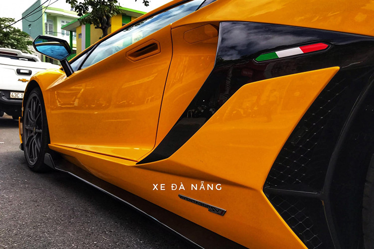 Bên hông siêu xe Lamborghini Aventador SVJ thứ 2 xuất hiện tại Việt Nam có thêm dải sọc 3 màu trắng, xanh lá cây và đỏ tượng trưng cho Quốc kỳ Ý, logo Aventador SVJ khá nhỏ ở sườn xe và khá bất ngờ là xe không có bộ tem SVJ nổi bật trên vòm bánh xe sau như chiếc Lamborghini Aventador SVJ đầu tiên về nước.