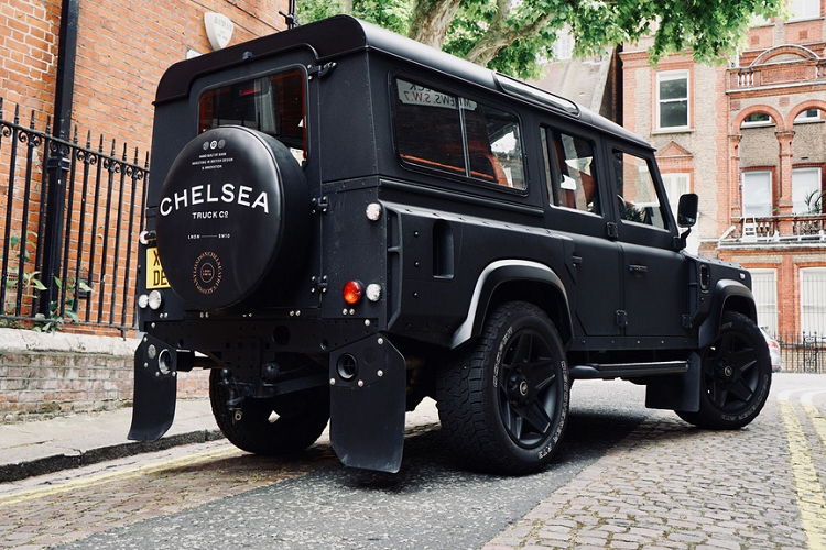Phần đuôi xe Land Rover Defender 110 độ này được Chelsea Truck tạo điểm nhấn với 2 tấm chắn bùn bằng cao su, nắp che bánh dự phòng được thiết kế riêng với tên công ty độ in nổi bật ngay giữa. Ngoại thất của xe được sơn lại màu đen nhám mang tên Volcanic Rock Stain.