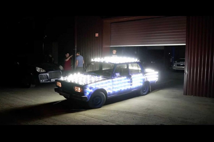 Số đèn led độ trên xe Lada tỏa sáng đến độ người nhìn không thể phân biệt nổi đường nét của chiếc xe từ trên cao. Từ góc nhìn mặt đất, ánh sáng phản xạ khỏi thân vỏ và mang đến cho chiếc xe một màu xanh nhạt.