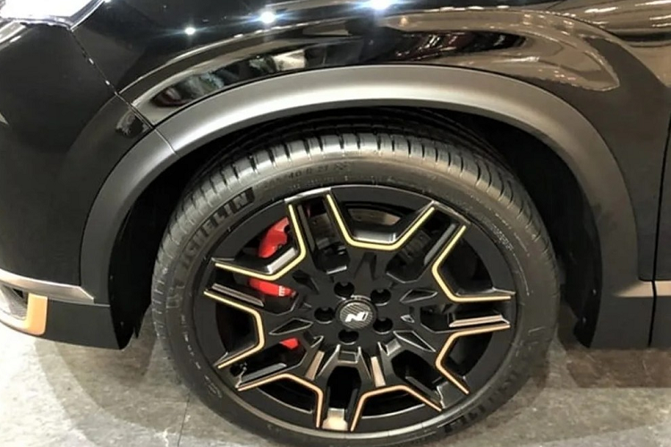 Thêm vào đó là bộ vành 21 inch, 7 chấu được sơn màu đen với viền chấu màu vàng "tông xuyệt tông". Nằm sau bộ vành hợp kim này là cùm phanh màu đỏ nổi bật. Chưa hết, Hyundai SantaFe N Performance còn đi kèm vỏ gương ngoại thất bọc sợi carbon, cánh gió mui được chia thành 2 mảnh và không tích hợp đèn phanh trên cao. Bên dưới xuất hiện bộ khuếch tán và 4 đầu ống xả giả. Trên cản sau, đèn phản quang của Hyundai Santa Fe N Performance được tách đôi thay vì nối liền nhau như xe tiêu chuẩn.