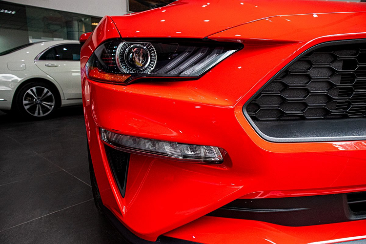 Cụ thể, đầu xe Ford Mustang Convertible 2020 có cụm đèn pha Bi-Xenon với tạo hình dữ dằn kết hợp cùng đèn chạy ban ngày 3 dây LED đầy ấn tượng như vuốt hổ. Ở cụm đèn pha trên chiếc xe hơi mới này cũng được kết hợp với đèn xi-nhan LED. Trong khi đó, đèn sương mù được chuyển xuống dưới kết hợp cùng hốc gió phía trước tạo thành hình móc câu.