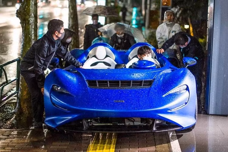 Qua những hình ảnh này, có thể thấy cảnh 5 người đàn ông "đánh vật" với chiếc siêu xe McLaren Elva màu xanh nhám trong cơn mưa lớn trên một con đường của thủ đô Tokyo, Nhật Bản. 1 người ngồi trong xe trong khi 4 người đàn ông khác gồng mình lên để đẩy chiếc McLaren Elva trên đường. Cuối cùng, chiếc McLaren Elva được đưa lên thùng sau ôtô tải.