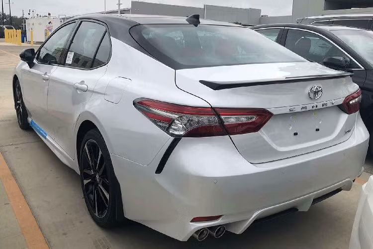 Đuôi xe được gắn thêm cánh lướt gió liền thân ở phía sau và sườn xe. “Dàn chân” được thay mới mang hai tông màu thể thao. Ngoài ra, nóc xe cũng được dán đen “sao y bản chính” với phiên bản Camry XSE. Chưa dừng lại đó, chủ xe Camry còn dán tem trang trí hai bên hông lấy cảm hứng từ các phiên bản “Edition One” của Mercedes-AMG.