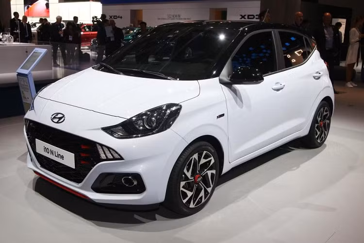 Thân xe thể thao Hyundai i10 N Line giá rẻ ghi nhận sự góp mặt của bộ mâm xe hợp kim 16 inch mới. Ở phía sau, đuôi xe nổi bật với cặp đèn hậu LED, hệ thống ống xả đôi bọc crom đặt lệch và dải viền màu đỏ cản trước/sau. Điểm đáng tiền của bản hiệu suất cao so với bản thường nằm ở bộ ốp gầm bảo vệ và khuếch tán sau.