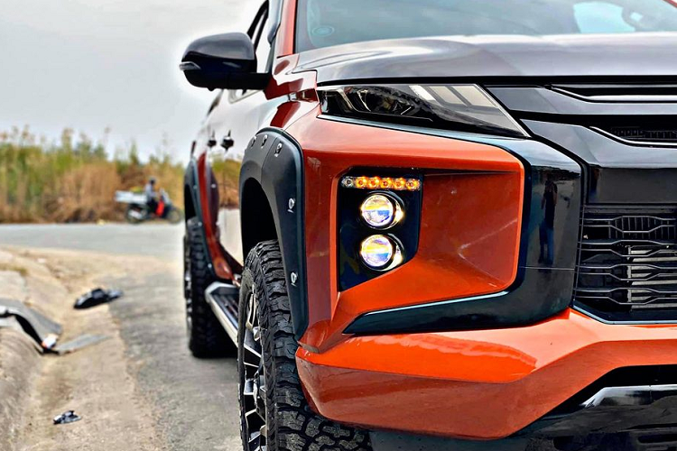 Một số chi tiết độ lại nổi bật của chiếc Mitsubishi Triton 2020 mới này có thể liệt kê như phần nắp ca-pô dán đề can đen, mặt ca-lăng sơn đen, cụm đèn chiếu sáng chính được thay thế bởi 2 bi projector LED cho cường độ ánh sáng cao hơn, đèn xi-nhan LED mới, gương xe sơn đen, mâm xe, cản sau và thanh thể thao mới...