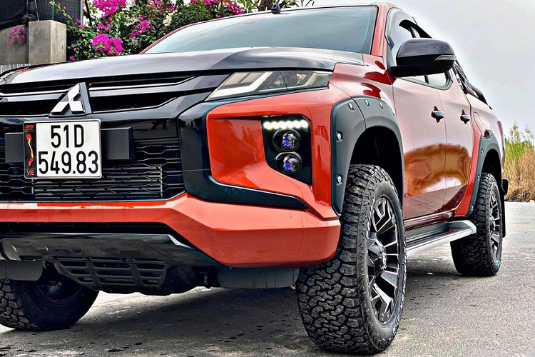 DDáng chú ý, phần đèn chiếu sáng đã được thay thế sang bi Projector LED mới. Việc sơn đen nhiều chi tiết ở đầu xe, kết hợp với tông màu cam ngoại thất càng gia tăng diện mạo khoẻ khoắn và độc đáo cho chiếc Triton độ