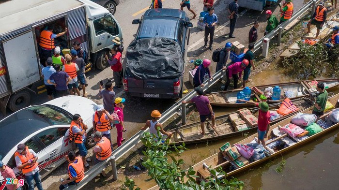Hàng cứu trợ được chuyển xuống ghe, xuồng nhỏ của người dân địa phương.