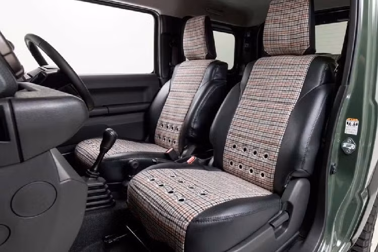 Nằm trong gói nâng cấp, khách hàng có thể tùy chọn bọc lại ghế ngồi với chất liệu da kết hợp cùng vải nỉ họa tiết sọc ca-rô cổ điển. Những chi tiết khác ở nội thất của Suzuki Jimny được giữ nguyên.