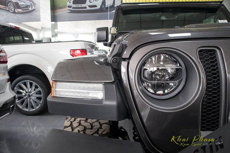 Đầu xe địa hình Jeep Wrangler Rubicon 2020 đầu tiên về Việt Nam cứng cáp nhờ cản trước tách biệt sơn đen sần cùng móc kéo và cuộn tời chuyên phục vụ việc Off-Road. Phần cản trước này còn được trang bị dàn đèn LED hỗ trợ việc di chuyển ở điều kiện thời tiết xấu.